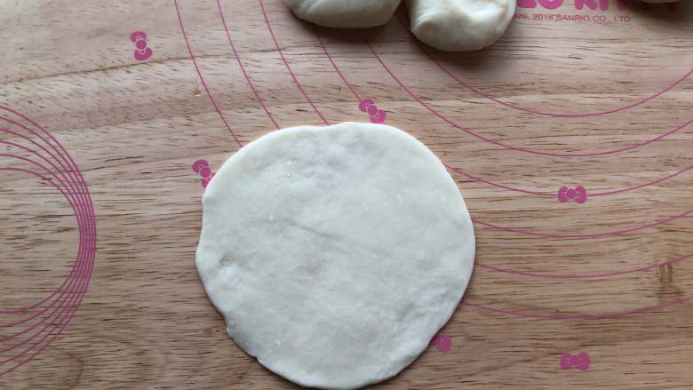 四喜蒸饺,撒上干面粉,用手掌按一下。擀好饺子皮备用。