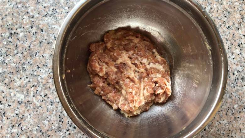玫瑰蒸饺,分次倒入葱姜水,搅拌至葱姜水和肉馅完全融合在一起。