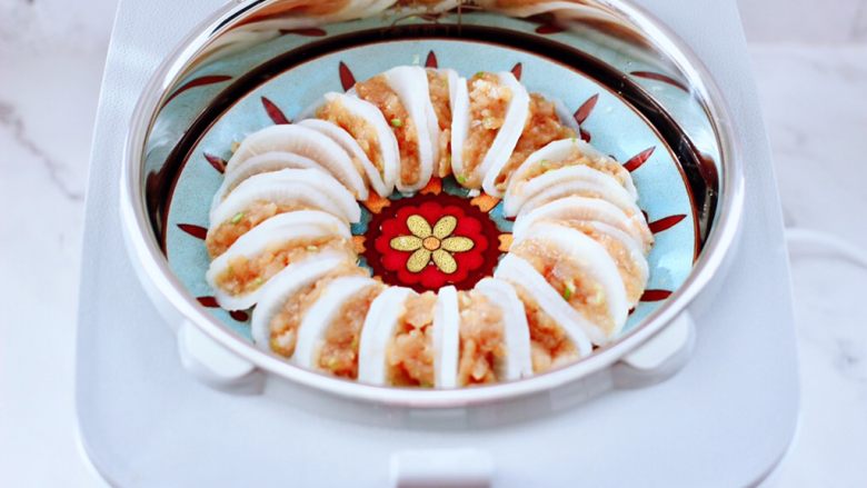 萝卜酿鸡肉~(电饭煲版),把萝卜酿鸡肉放到蒸屉上,脱糖煲不仅可以蒸饭,蒸菜也是杠杠滴,是靠主锅把水烧沸后,提供的全方位循环加热,使锅中的食物充分吸收了蒸汽,蒸出来的萝卜酿鸡肉,鲜嫩爽口又好吃哟。