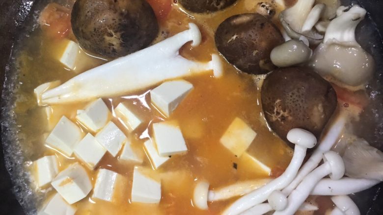 番茄菌菇豆腐汤,水开始沸腾后,加入刚才准备的豆腐块、4个整个<a style='color:red;display:inline-block;' href='/shicai/ 230'>香菇</a>、金针菇!