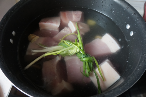 香菇卤肉丁包,先来做卤肉,肉块儿放入冷水锅中,放上几片姜和葱。水开冒3分钟用勺子撇去血沫。捞出控水。