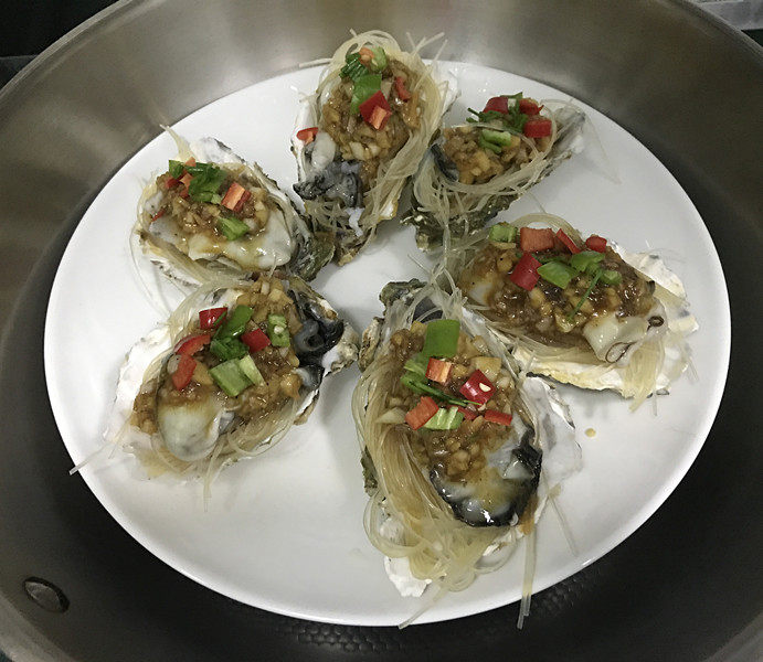 蒜蓉粉丝蒸生蚝,然后用小勺将蒜蓉汁,均匀地浇在每个生蚝上面