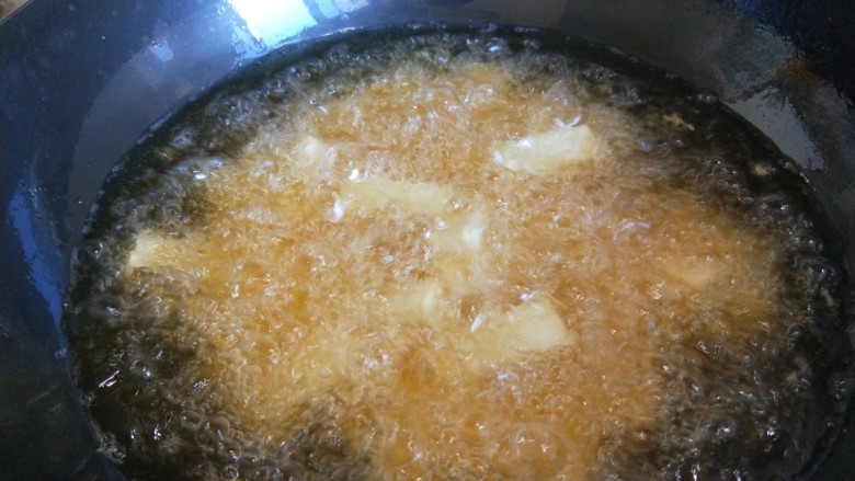 鱼香脆皮豆腐,油温要热,有烟冒出来就是70度左右,倒入豆腐炸制。