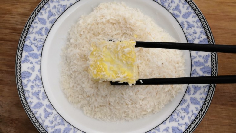 鱼香脆皮豆腐,把粘满鸡蛋液的豆腐,滚上一层面包糠,备用