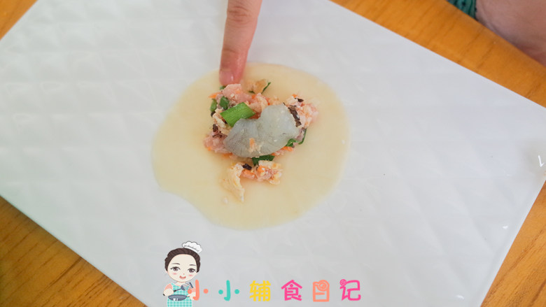 12个月以上辅食香煎三鲜饺子,准备饺子皮放入肉馅加一颗虾仁,周围沾水对半粘合即可