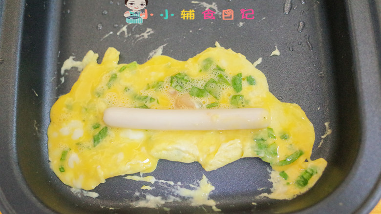 12个月以上辅食小黄人厚蛋烧,有点凝固就放香肠,慢慢往上卷