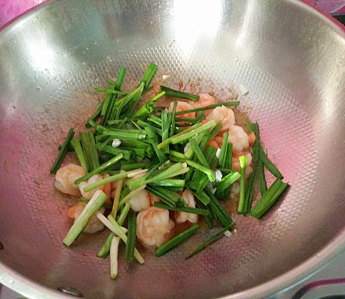 青蒜爆虾球,待芡汁变浓稠明亮后、倒入蒜叶和煸炒过的蒜白,快速翻炒均匀即后