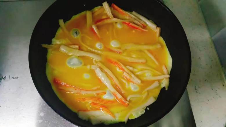 食材简单,调料简单,味道却不简单的蟹棒滑蛋,蟹棒炒至发胖,就是平时吃火锅那种胀大的样子,很好观察的,这时蟹棒已经炒熟,均匀倒入蛋液,铺满所有蟹棒。