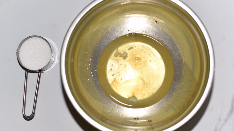 桂花杯子蛋糕,蛋白打入无水无油的盆中,用电动打蛋器高速打发,30克砂糖分三次加入。