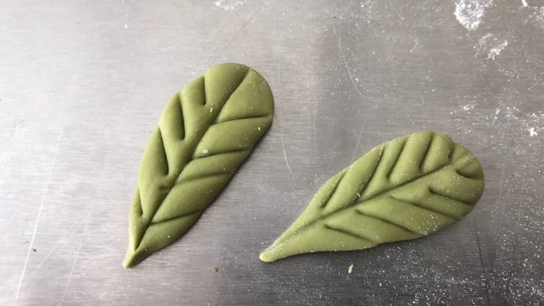 水蜜桃馒头,搓成水滴的形状,按扁,用刮板压出叶脉。