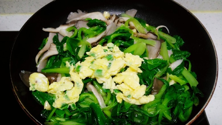 上海青炒平菇、鸡蛋,翻炒均匀,倒入鸡蛋