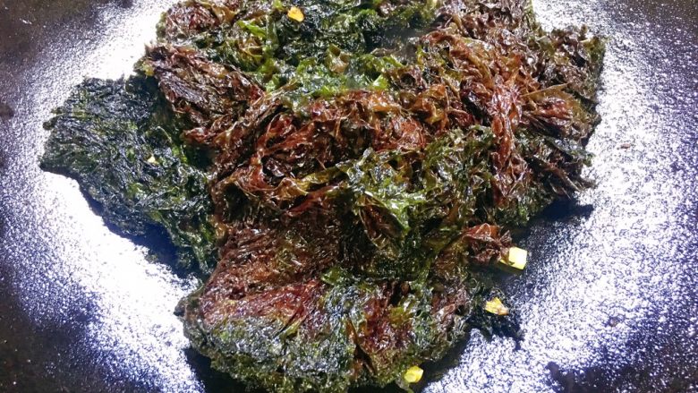 海蛎瘦肉紫菜煲,另起油锅,放入葱白段炒出香味,把紫菜也放入锅过油,炒至变色,后放入开水