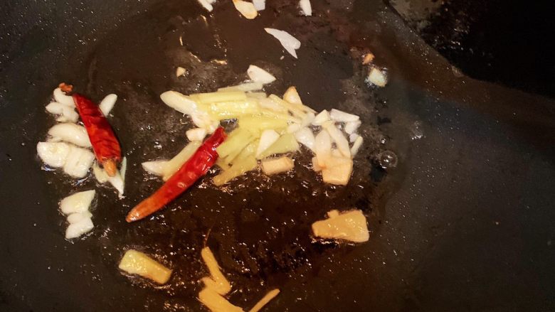 墨鱼仔炒芹菜,锅中熟油，加入蒜，姜爆香，加入两个干辣椒