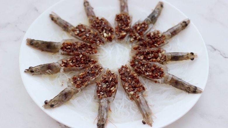 金蒜粉丝蒸海虾,把炒好的蒜末汁和<a style='color:red;display:inline-block;' href='/shicai/ 718'>料酒</a>,浇在虾肉上面。
