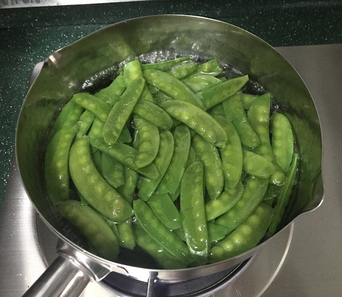 杂炒时蔬,锅中烧开水,放少许盐和食用油,倒入荷兰豆,焯烫30秒至微微变色后捞出
