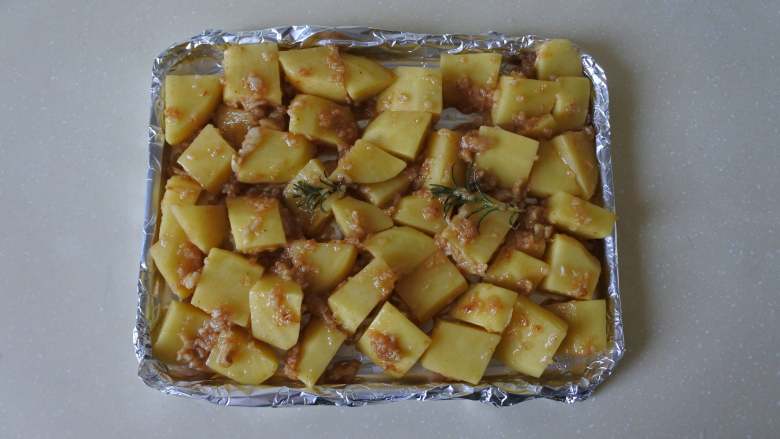 西式蒜香烤土豆,烤盘铺锡纸,倒入土豆铺平