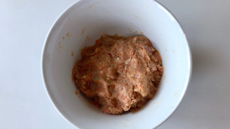 金灿灿的小米裹肉丸子,粗粮和肉的黄金搭档!,然后拿筷子顺着一个方向搅拌上劲。