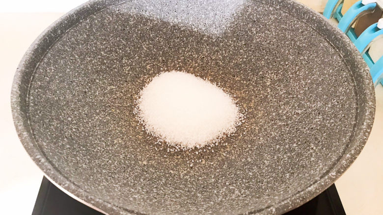 盐焗花生米,炒锅烧热后放入白砂糖,小火翻炒