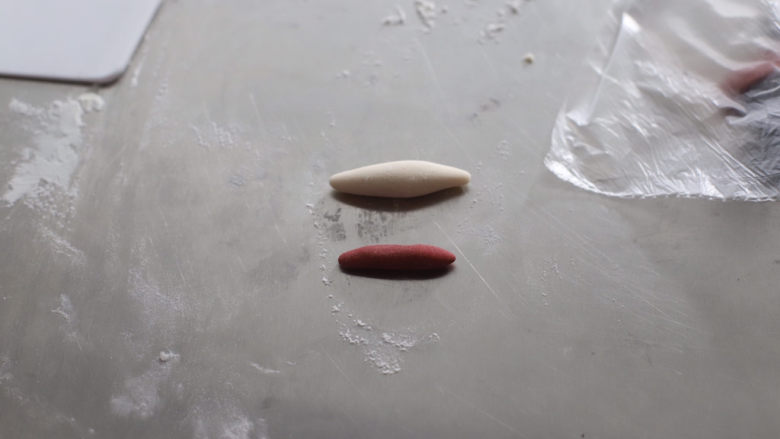可妮兔馒头,取出3克白色面图,1.5克红色面团都搓成圆柱形,用手稍稍按扁
