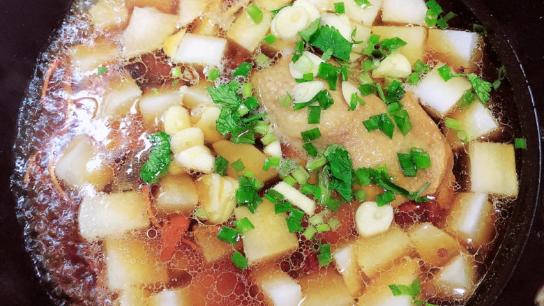 老鸭粉丝汤,放入葱蒜,继续炖煮。