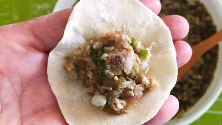 冬至美食 黄蘑猪肉馅水饺,取一个饺子皮,加入一勺馅料
