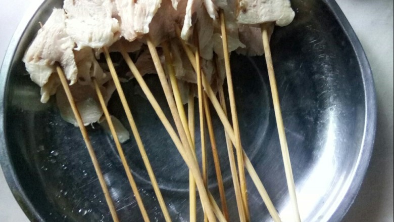 冬至美食 藤椒钵钵鸡,将鸡肉片用竹签穿好。
