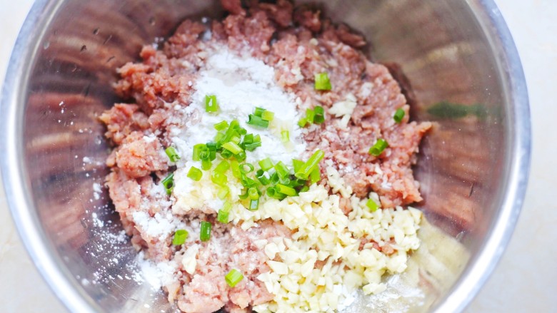 冬至美食 清香可口的珍珠藕丸,猪肉末放入大盆中,加入两勺玉米淀粉,蒜末,葱末。