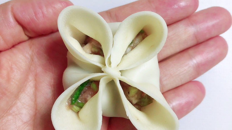 冬至美食 喜庆四喜蒸饺,再将另两面的皮子粘住,露出四个孔。