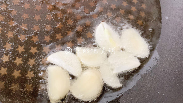冬至美食 嫩牛五方,起油锅,把蒜片放入炸香后捞出。
