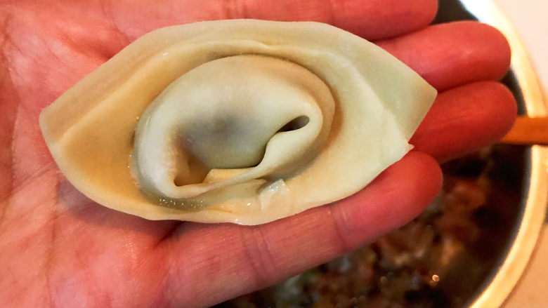 海鲜小馄饨,中间对折,把两边的角捏在一起,一个馄饨就包好了