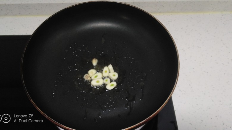 冬至美食+西葫芦炒胡萝卜、粉条、面鱼,锅中放入适量油,炒香蒜片