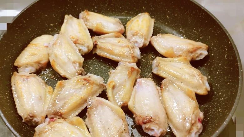 冬至美食 雪梨鸡翅,锅中放入食用油 油热后放入腌好的鸡翅中 煎至2面微微焦黄 取出备用