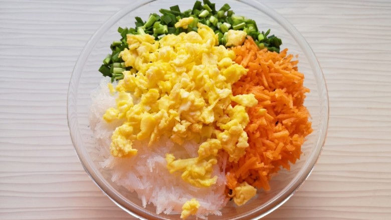 冬至美食 饺子皮小笼包,将准备好的韭菜、胡萝卜、粉丝和鸡蛋一起放进大一点的盆里,加入<a style='color:red;display:inline-block;' href='/shicai/ 847'>香油</a>搅拌均匀。