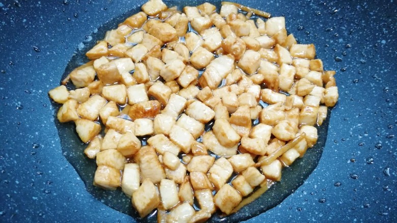 冬至美食 毛豆炒鸡丁,炒锅内倒适量的食用油烧热,下入腌好的鸡丁炒熟,盛出备用。