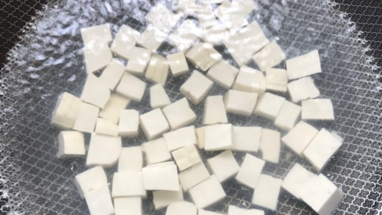 花蛤豆腐汤,水开后倒入豆腐,盖上锅盖焖煮8分钟。