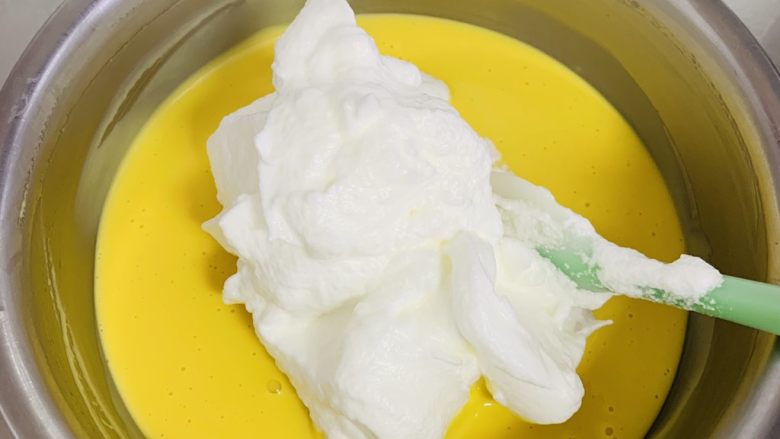 古早蛋糕,取三分之一的蛋白加入到蛋黄糊里,用翻拌的手法拌均匀。