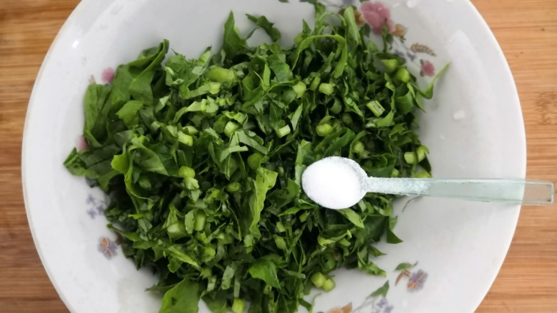 冬至美食 萝卜缨子炒年糕,把萝卜缨子丝,放入碗中,加入2克盐