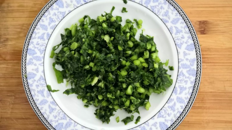 冬至美食 萝卜缨子炒年糕,萝卜缨子,冲洗干净后,挤干水份,放入盘中,备用