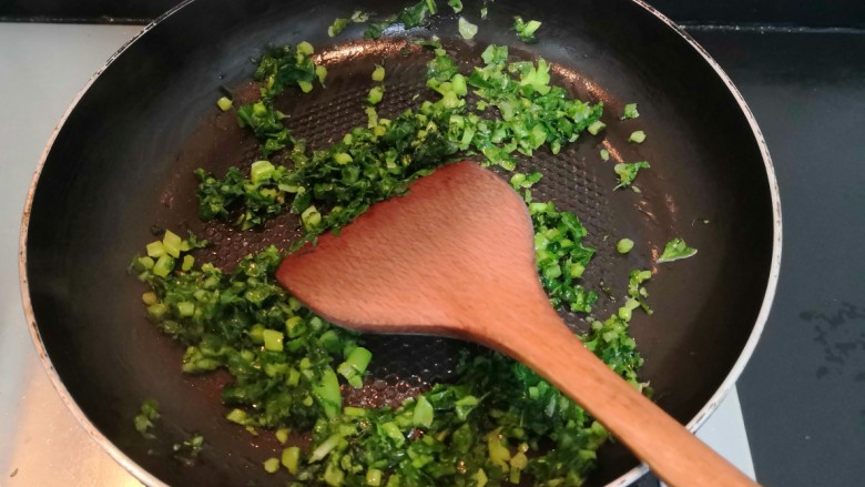 冬至美食 萝卜缨子炒年糕,用铲子,把萝卜缨子,翻炒均匀