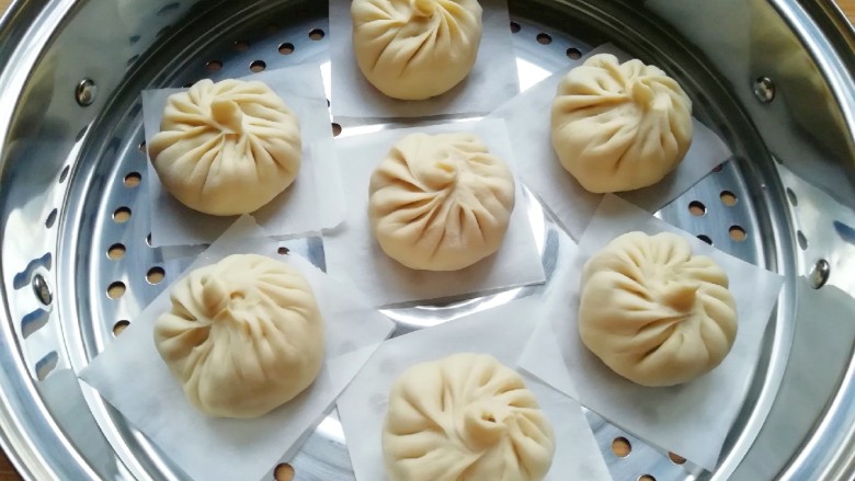 冬至美食 南瓜馅包子,蒸锅内放水,篦子上铺上油纸,放上做好的包子生胚,盖上锅盖二次发酵10分钟左右,凉水上锅,上汽后大火蒸10分钟关火,焖5分钟左右出锅。