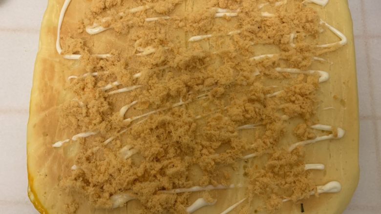 香葱肉松面包卷儿,凉到手温的时候,用小刀在面包片上切数条小口,不要切断了,再挤上沙拉酱,撒上肉松