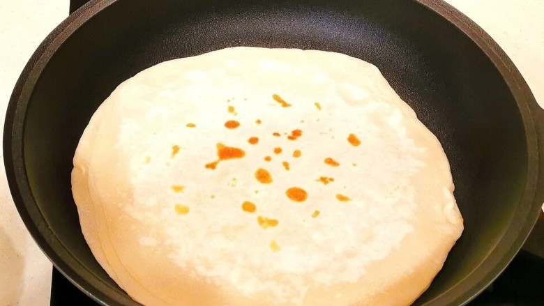 鸡蛋韭菜盒子,盖上盖子在烙一分钟,再翻面,取最上面那张,以此类推,直至烙好饼皮