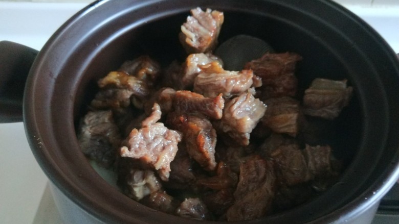 五香酱牛肉,调料放锅底,倒入炒制的牛肉。