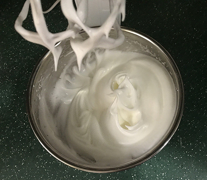 草莓欧蕾,开启电动打蛋器,先用低速将白糖打至融化,再转高速将蛋白打至光滑细腻的湿性发泡状