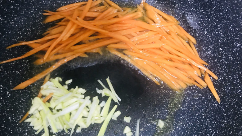 家庭版土豆丝,锅烧热油下胡萝卜丝和葱蒜炒2分钟