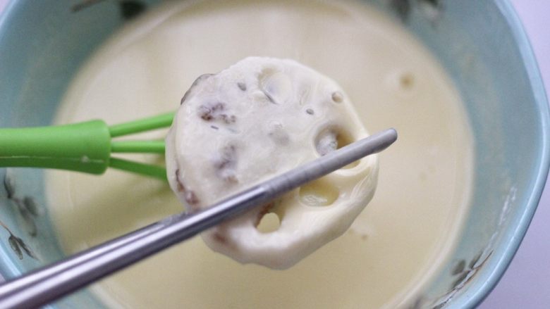 藕夹肉,锅中倒入适量的花生油烧至六成热时,把藕盒放入面糊里均匀地裹上一层薄薄的面糊。