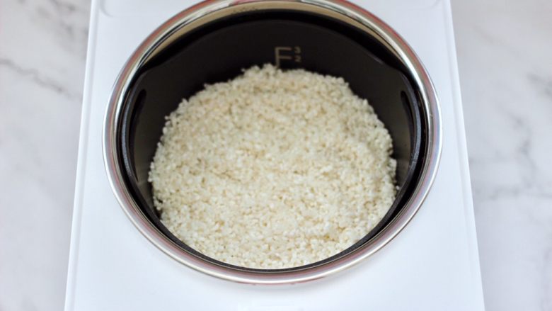 绿豆红薯饭,把浸泡后洗净的大米，放入臻米脱糖养生蒸汽饭煲的甑锅里。