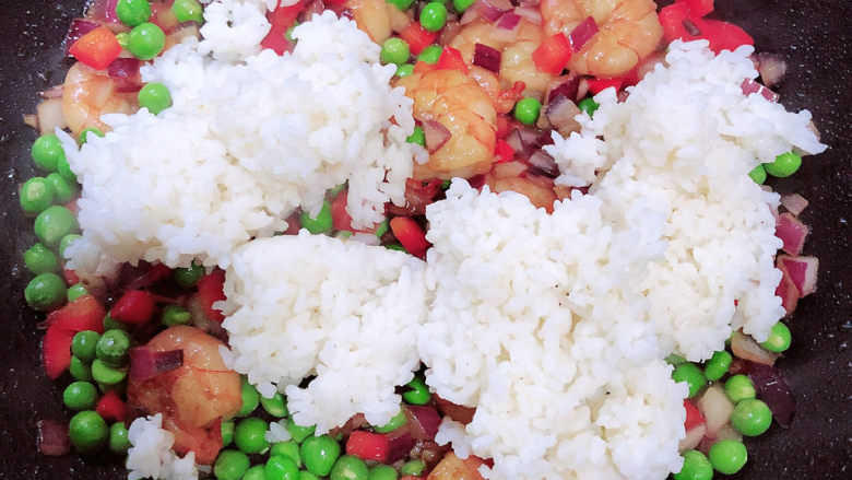 菠萝虾仁炒饭,放入米饭翻炒均匀,用铲子将米饭打散成米粒状。