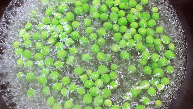 菠萝虾仁炒饭,锅中烧开水,放入豌豆煮5分钟,捞出待用。