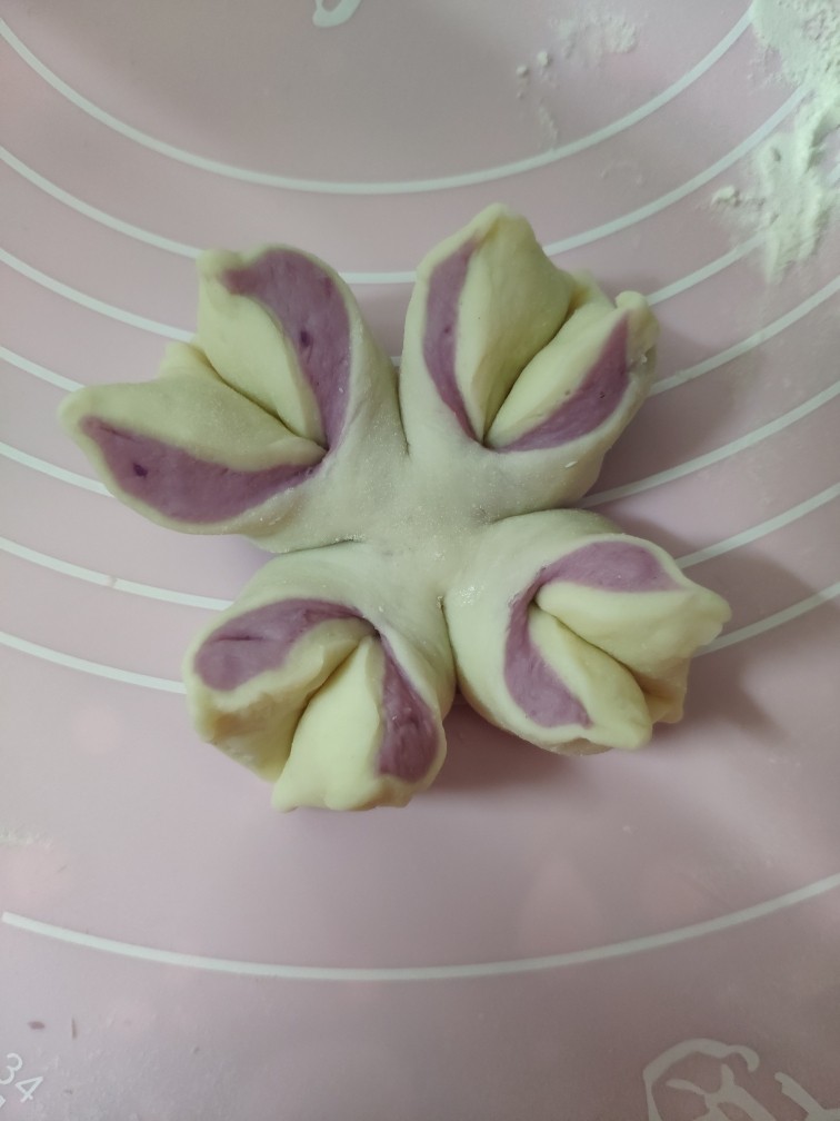 紫薯花朵馒头,两片花瓣一左一右向外转一下,底部捏紧就完成了